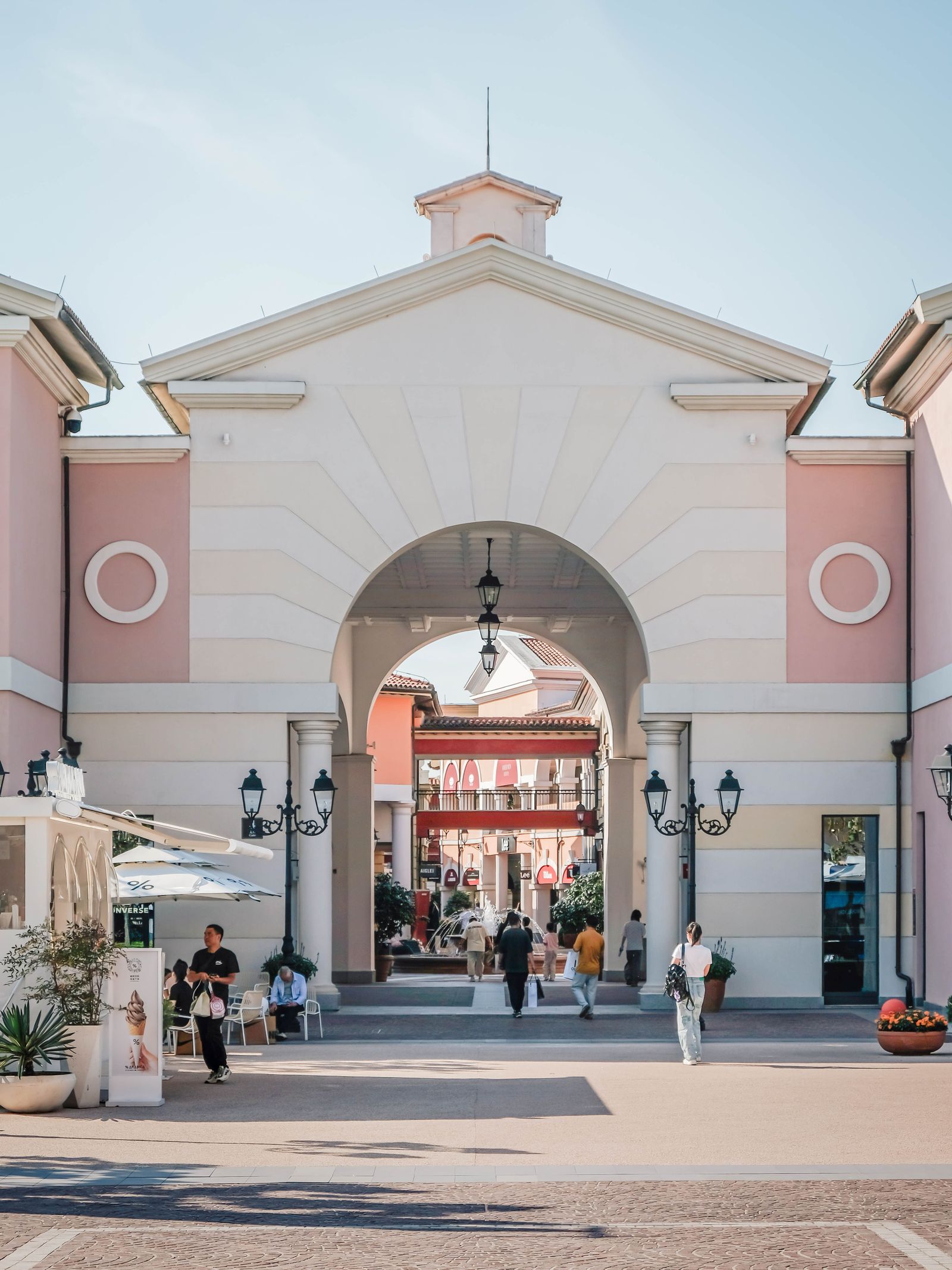 Open-air shopping center with an arched entrance and storefronts