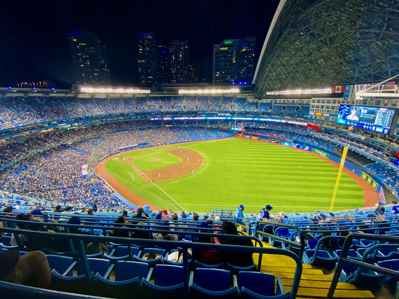 A packed baseball stadium illuminated for a night game