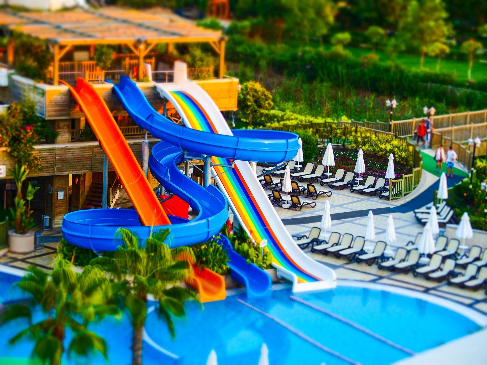 Brightly colored water slides descending into a resort pool